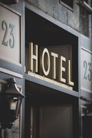 Un letrero de hotel con la palabra 'HOTEL' en letras grandes, flanqueado por el número '23' a cada lado.