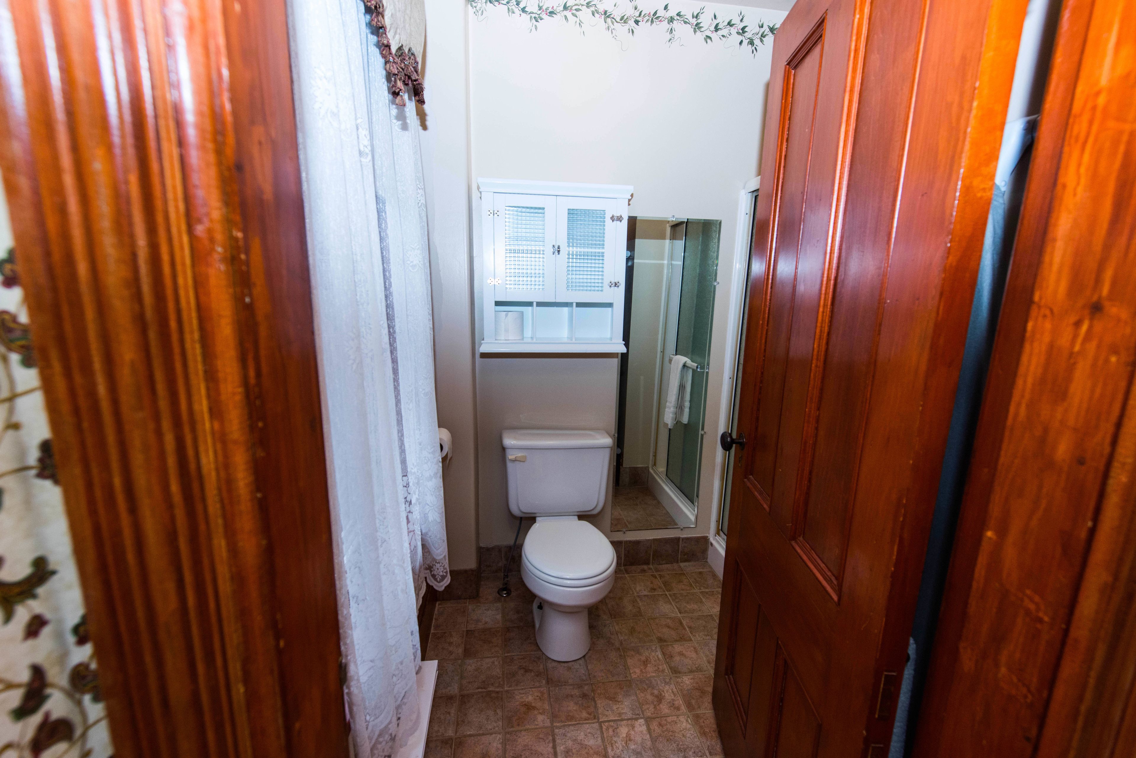 Une petite salle de bain comprenant des toilettes, un petit meuble et un espace douche.