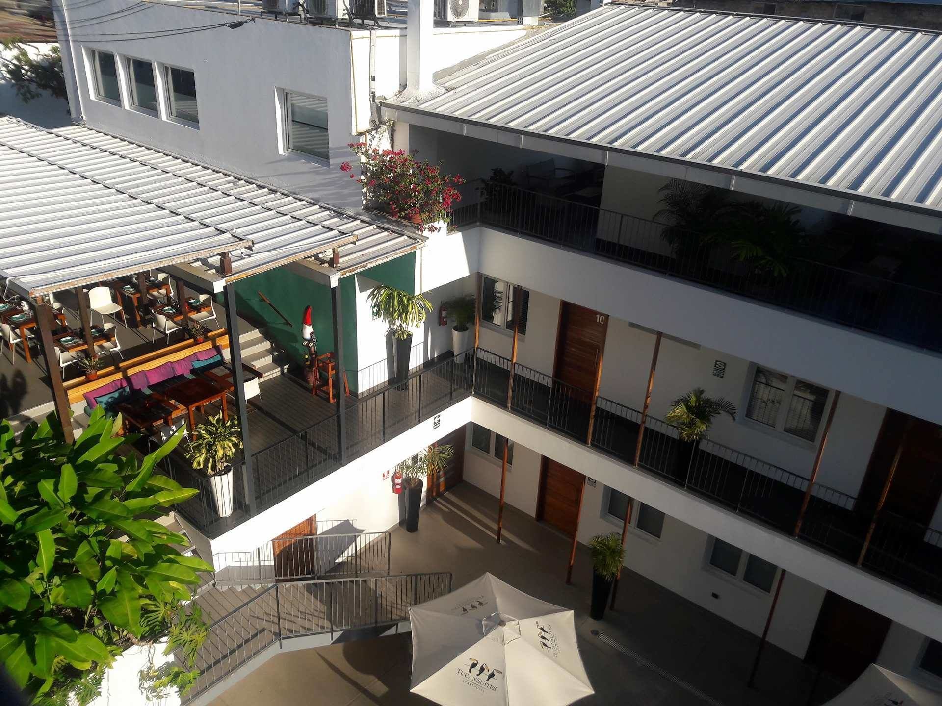 A multi-story building with a rooftop terrace, outdoor seating area, and balconies.