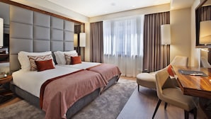 Una habitación de hotel moderna con una cama grande, un escritorio y una silla.