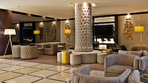 Un lobby lujoso con asientos cómodos, una columna grande y una decoración moderna.