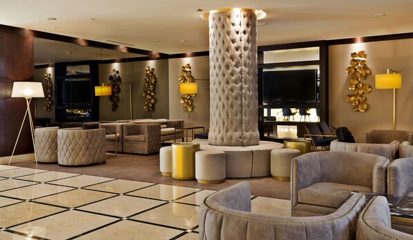 A luxurious lobby with plush seating, a large column, and modern decor.
