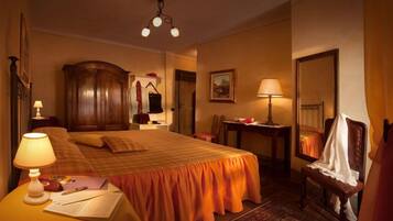 Ein Hotelzimmer mit einem großen Bett, einem Schreibtisch, einem Stuhl, einem Kleiderschrank und einem Spiegel.