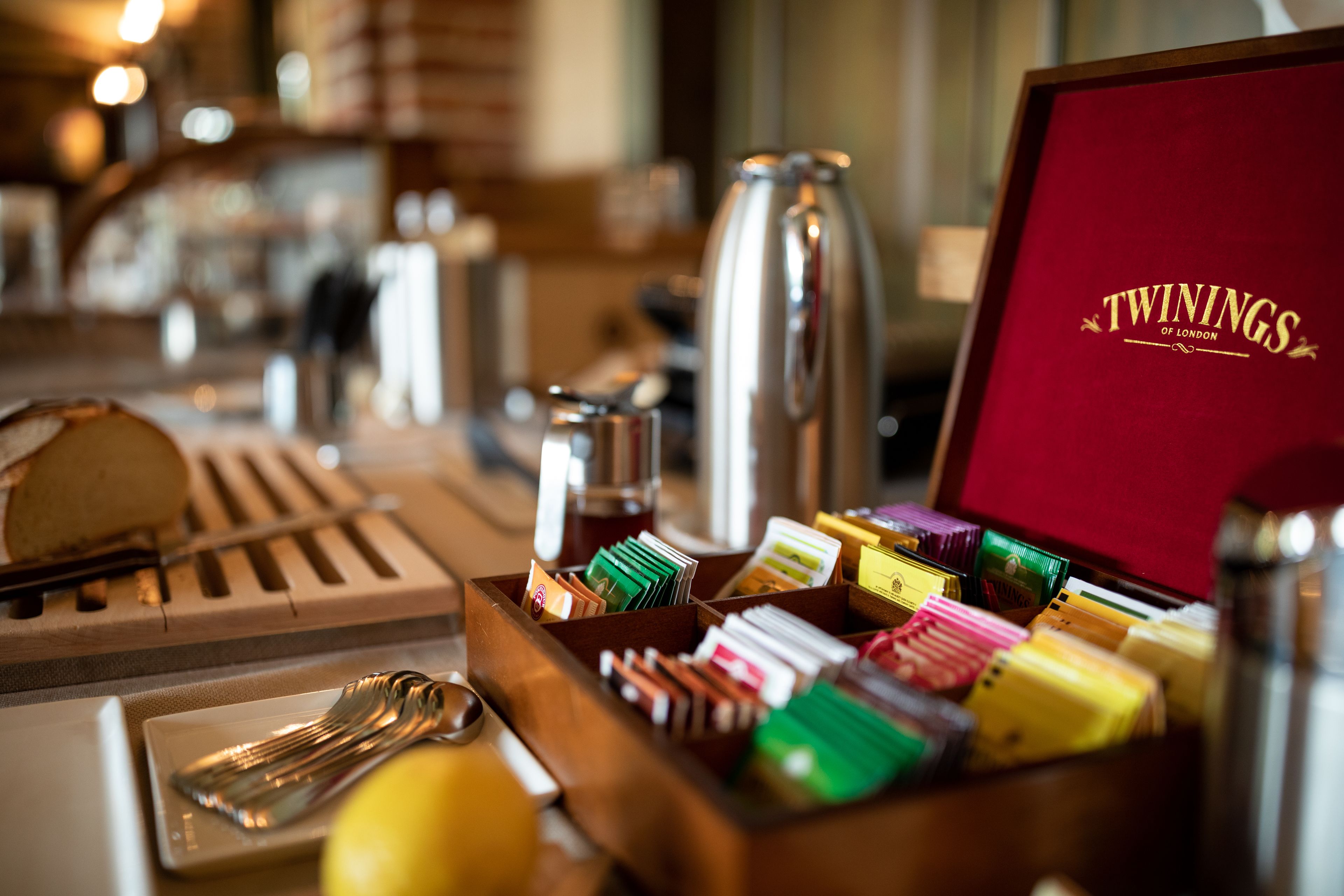 A tray with various items including a loaf of bread, a knife, a lemon, and a box labeled "TWININGS OF LONDON".