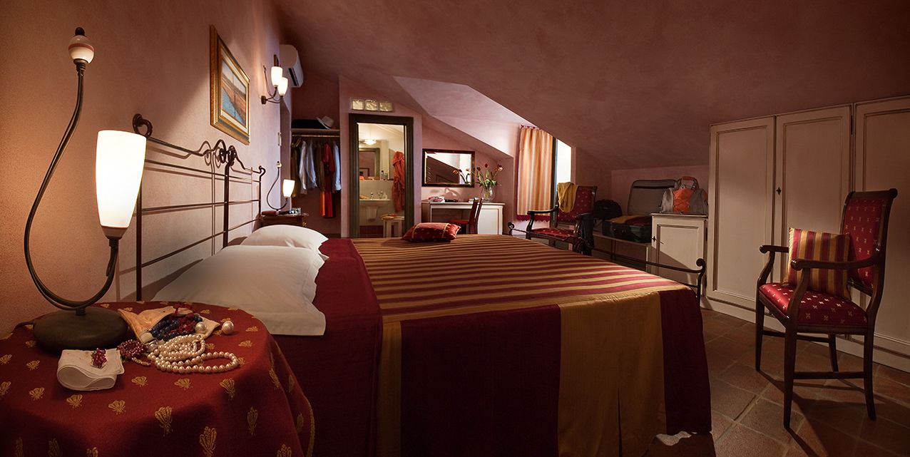 Una habitación de hotel con una cama grande, un escritorio, una silla y un armario.