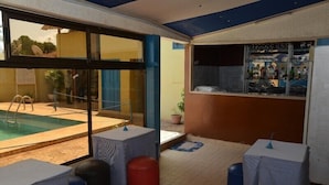 A pool area with a bar and seating. - Hôtel Résidence Les Anges (Lomé)