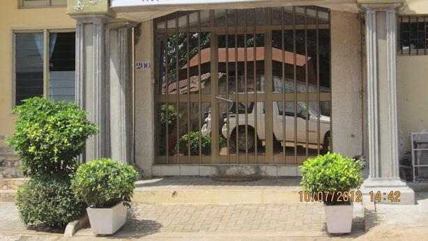 A hotel entrance with a sign reading "Residence Hotel" and a vehicle parked inside. - Hôtel Résidence Les Anges (Lomé)