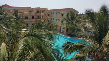 Relax by the resort's inviting pool surrounded by lush palm trees.