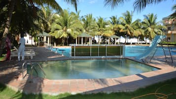 Una piscina al aire libre, sillones reclinables de piscina