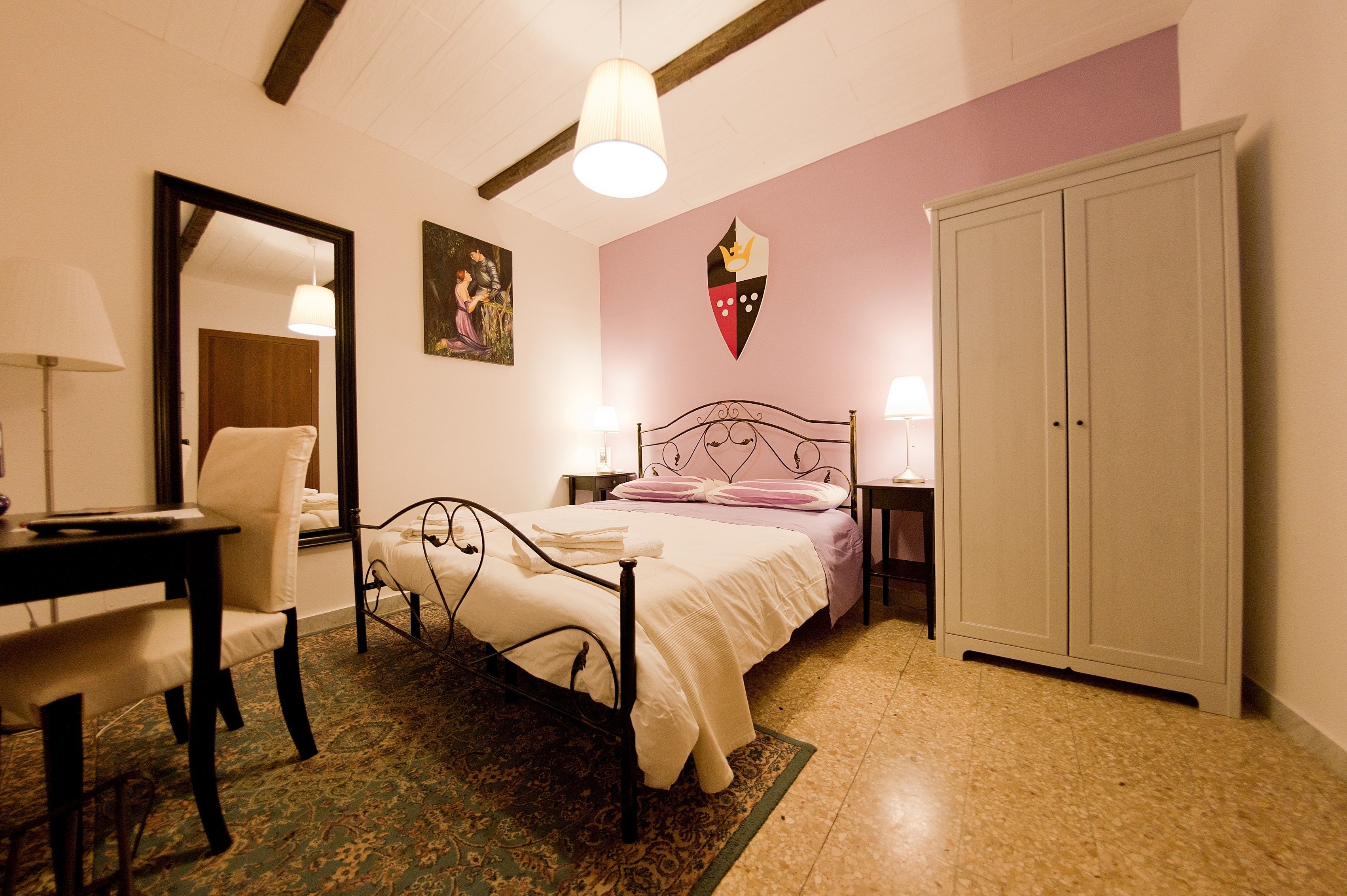 Un dormitorio con cama, escritorio, silla, armario y espejo.