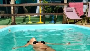 Una piscina con dos sillas de descanso y una valla de madera.