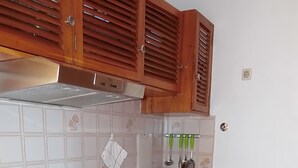 Eine Küche mit Holzausstattung, einem Gasherd, einer Spüle und einem Kühlschrank.