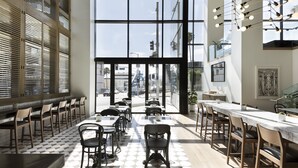 Um restaurante moderno com uma grande janela, cadeiras de madeira e bancada de mármore.