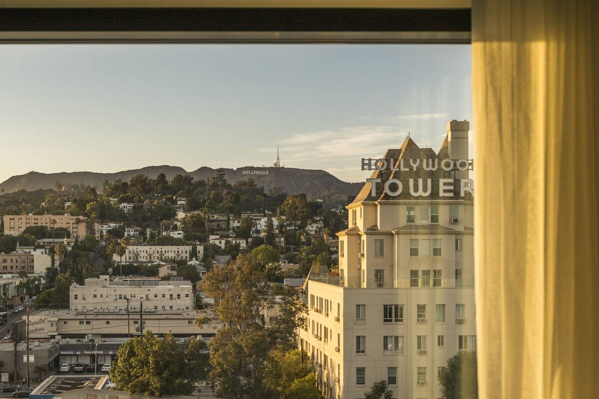 A view of Hollywood Tower with a backdrop of a cityscape and hills.