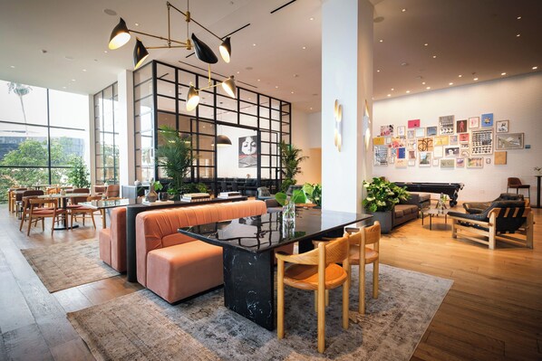 A modern, open-plan living area with a central island, seating arrangements, and a wall adorned with artwork.