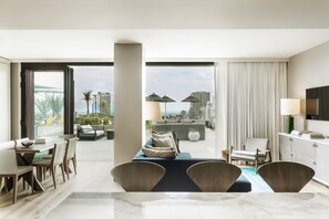 A modern hotel room with a dining area, a sofa, a TV, and a view of the cityscape. - Kimpton Everly Hotel Hollywood by IHG (Los Angeles)