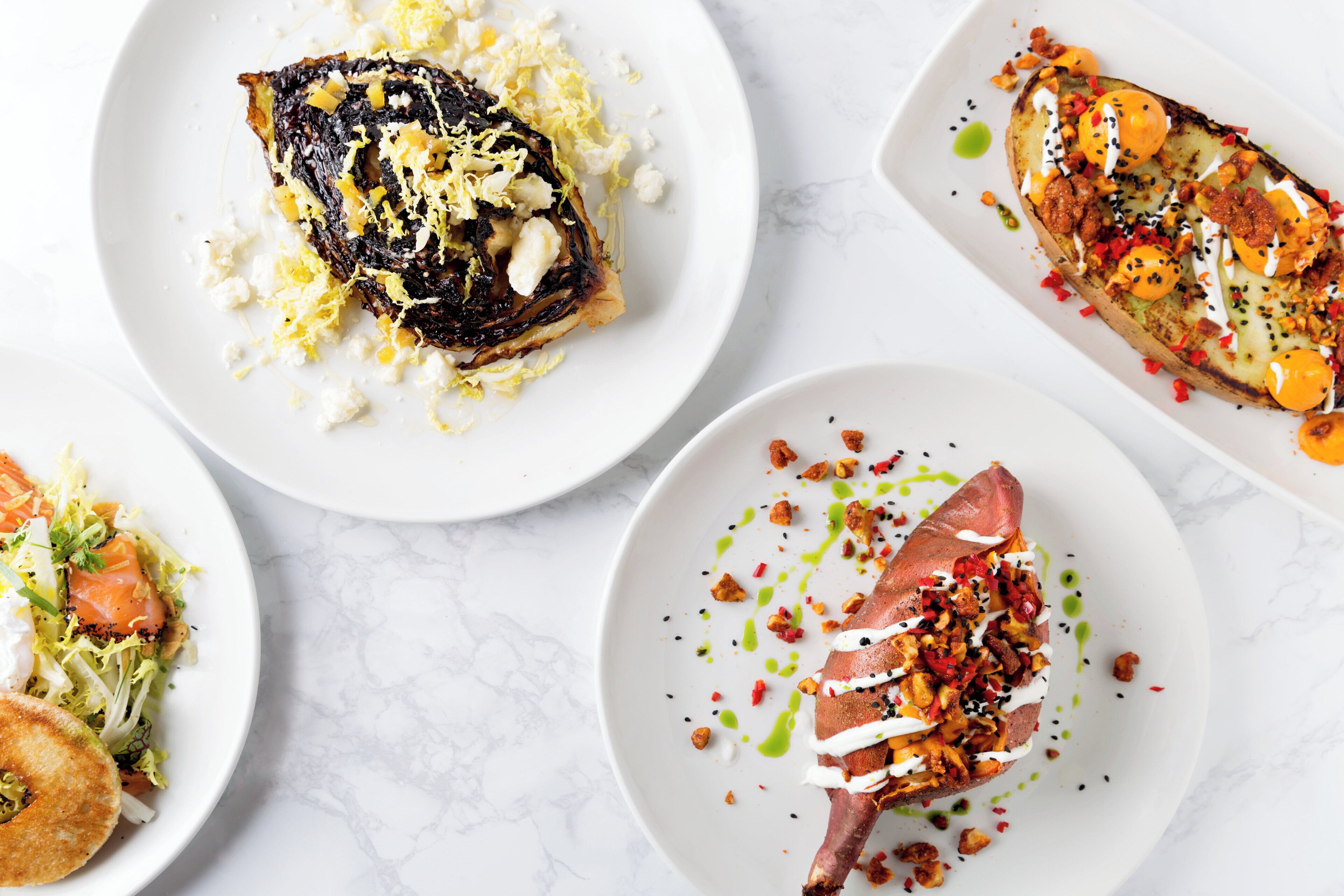A variety of dishes on white plates, suggesting a dining setting.