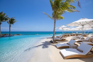 Una piscina al aire libre, sillones reclinables de piscina
