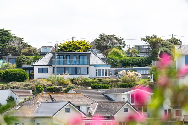 A modern two-story house with a flat roof, large windows, and a balcony. - Blue Bay House (Newquay)