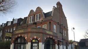 A building with 'The Grange' signage, featuring a brick facade and arched windows. - The Grange Pub (London)