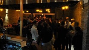 A crowded indoor space with exposed brick walls, wooden beams, and industrial-style lighting. - The Grange Pub (London)