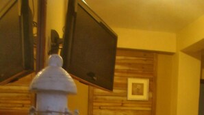 A room with a bed, a television mounted on the wall, and a decorative lighthouse. - Hotel Molina (La Ceiba)