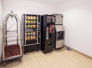 A vending machine with snacks, a water dispenser, and a return cart.