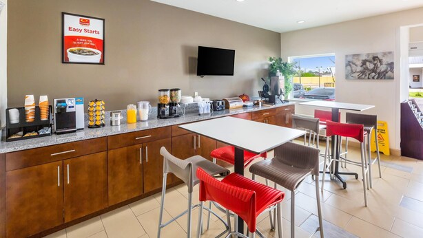 A modern kitchen area with a flat-screen TV, a coffee station, and a breakfast bar. - Econo Lodge Baton Rouge University Area (Baton Rouge)