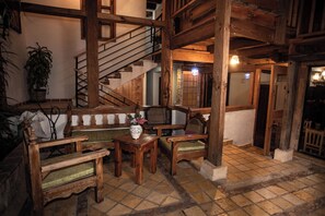 Un interior rústico con muebles de madera, una escalera y suelo de baldosas.