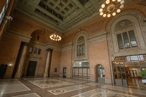 A spacious lobby with a high ceiling, large windows, and a patterned floor. - Grand Central Hotel Auckland (Auckland)
