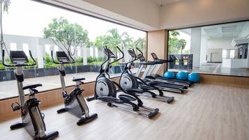 A gym with stationary bikes, treadmills, and exercise balls.