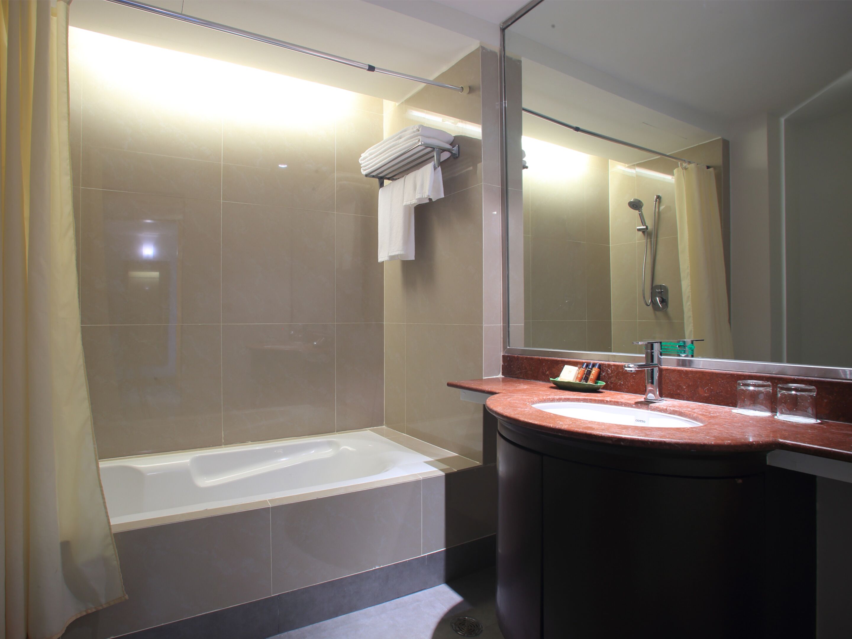A modern bathroom with a bathtub, a sink with a mirror, and a shower area.