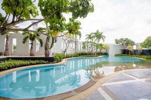 Una piscina al aire libre, sillones reclinables de piscina