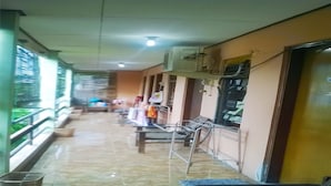 A corridor with benches, a trash bin, and an air conditioning unit mounted on the wall. - Kost Semarang Peterongan Timur (Semarang)