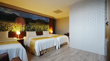 A hotel room with three beds, a large painting of a field and mountains, and a patterned wall.