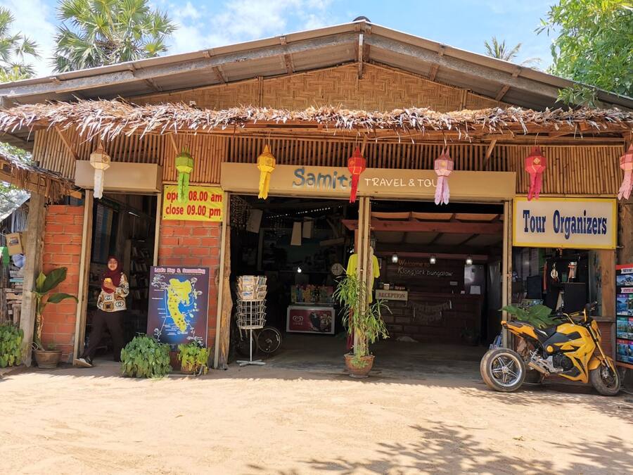 A travel agency named 'Samit' with a signboard indicating it is open from 08:00 am to 09:00 pm.