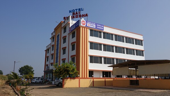 Um hotel com vários andares, com uma placa indicando ser o Hotel Sai Sharda.