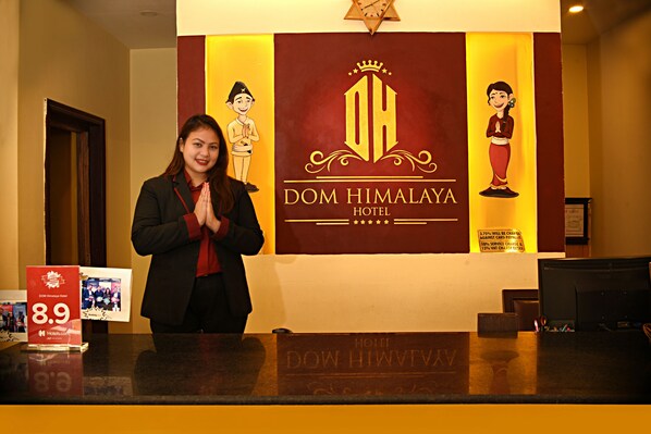 A reception desk at the DOM HIMALAYA HOTEL with a sign displaying the hotel's name and a star rating of 8.9. - DOM Himalaya Hotel (Kathmandu)