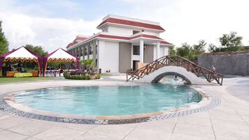 Relax by the resort's central pool, surrounded by a tiled deck and a wooden bridge.