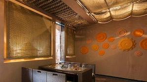 A dining area with a table set for four, wicker chairs, and decorative plates on the wall.