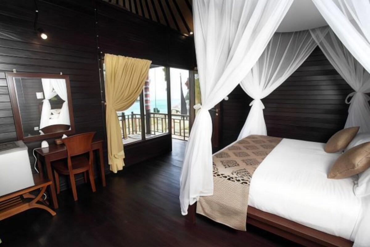 A bedroom with a bed, a desk, and a chair.