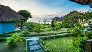 A courtyard with a water feature, lush greenery, and traditional architecture. - Bali Belva (Lembongan Island)
