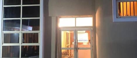 A building entrance with a glass door and windows.