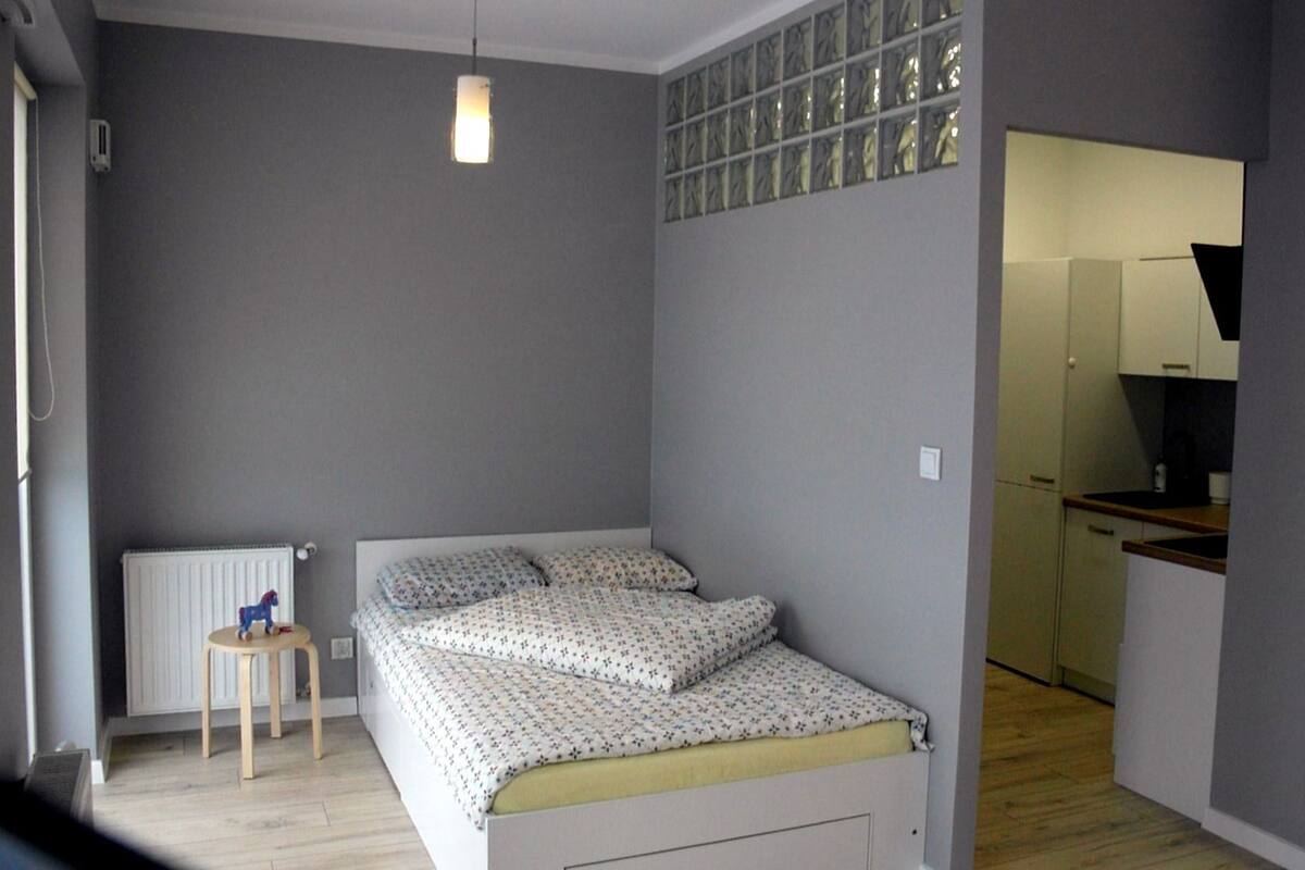 Une chambre à coucher avec un lit, une petite table et un radiateur.