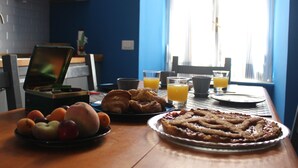 A breakfast table with croissants, a pie, and fruit. - Le Stanze di Pietro (Rome)