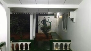 A staircase with a railing, a wall-mounted air conditioning unit, and a door with a decorative trim.