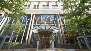 A modern building with a glass entrance and a covered entrance area. - Viale Osaka (Osaka)