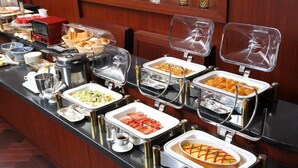 A buffet setup with various food items and a coffee station. - Viale Osaka (Osaka)