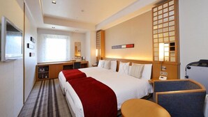 A hotel room with a large bed, a desk, a chair, and a small table. - Viale Osaka (Osaka)