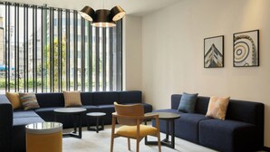 A modern living room with a sofa, two small tables, a chair, and a large window with vertical blinds. - City Express By Marriott Osaka Shin-Imamiya (Osaka)